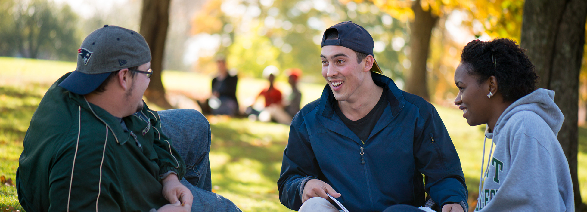 Students talking under trees outside during autumn on Randolph Center campus