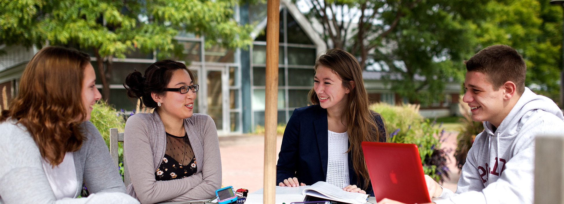 Vermont Academy of Science and Technology students study around a table outside on the Randolph Center Campus