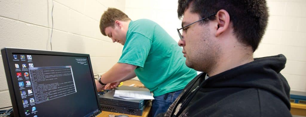 Two students work on IT equipment on the Randolph Center campus.