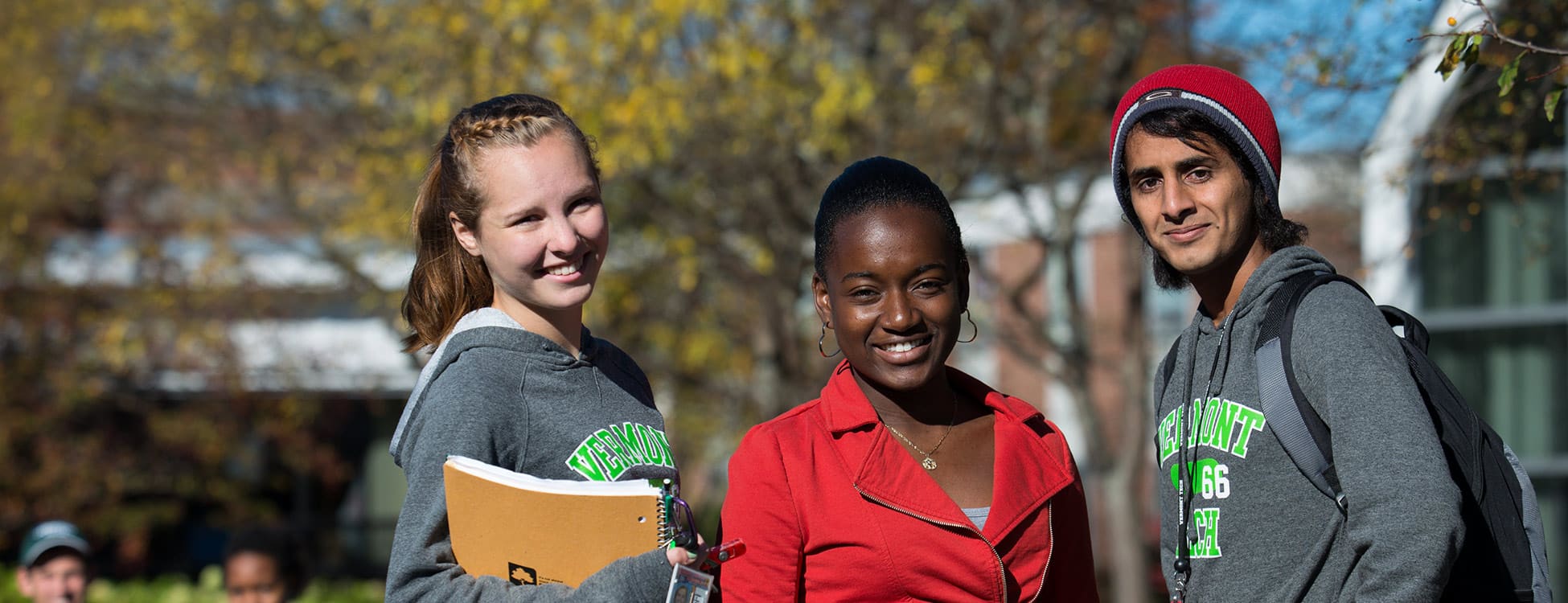 Three students posing for a picture on the plaza outside on the Randolph Center campus, diversity