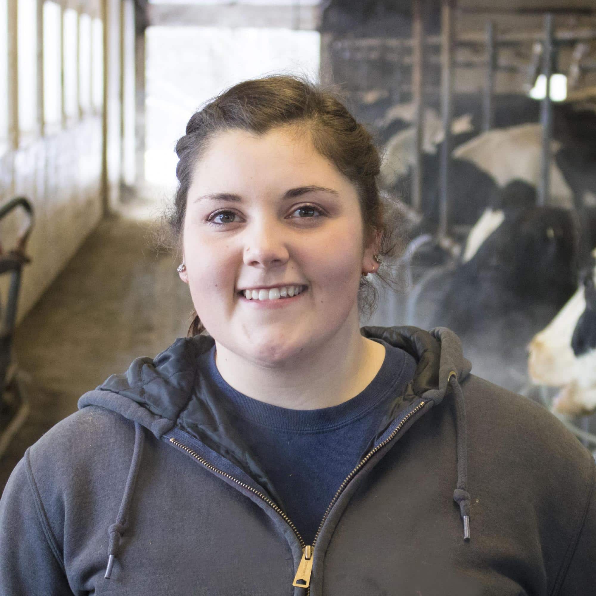 Rachael Burt works in the cow barn on the Randolph Center campus