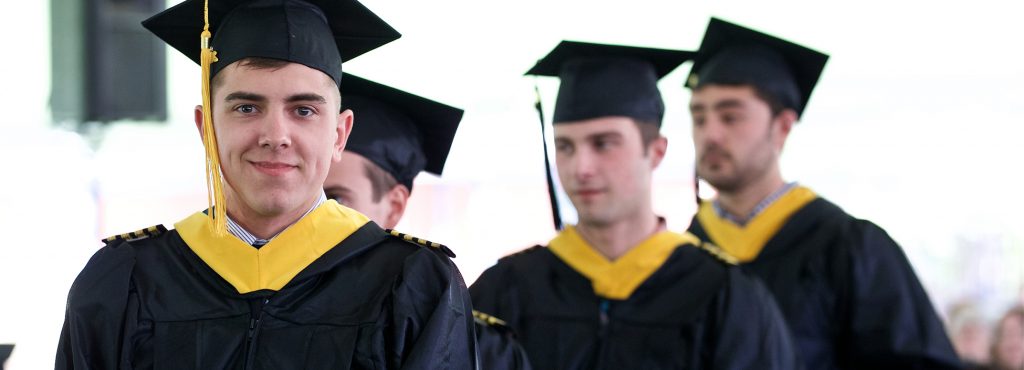 Graduates line up for their diplomas under the tent, commencement, graduation