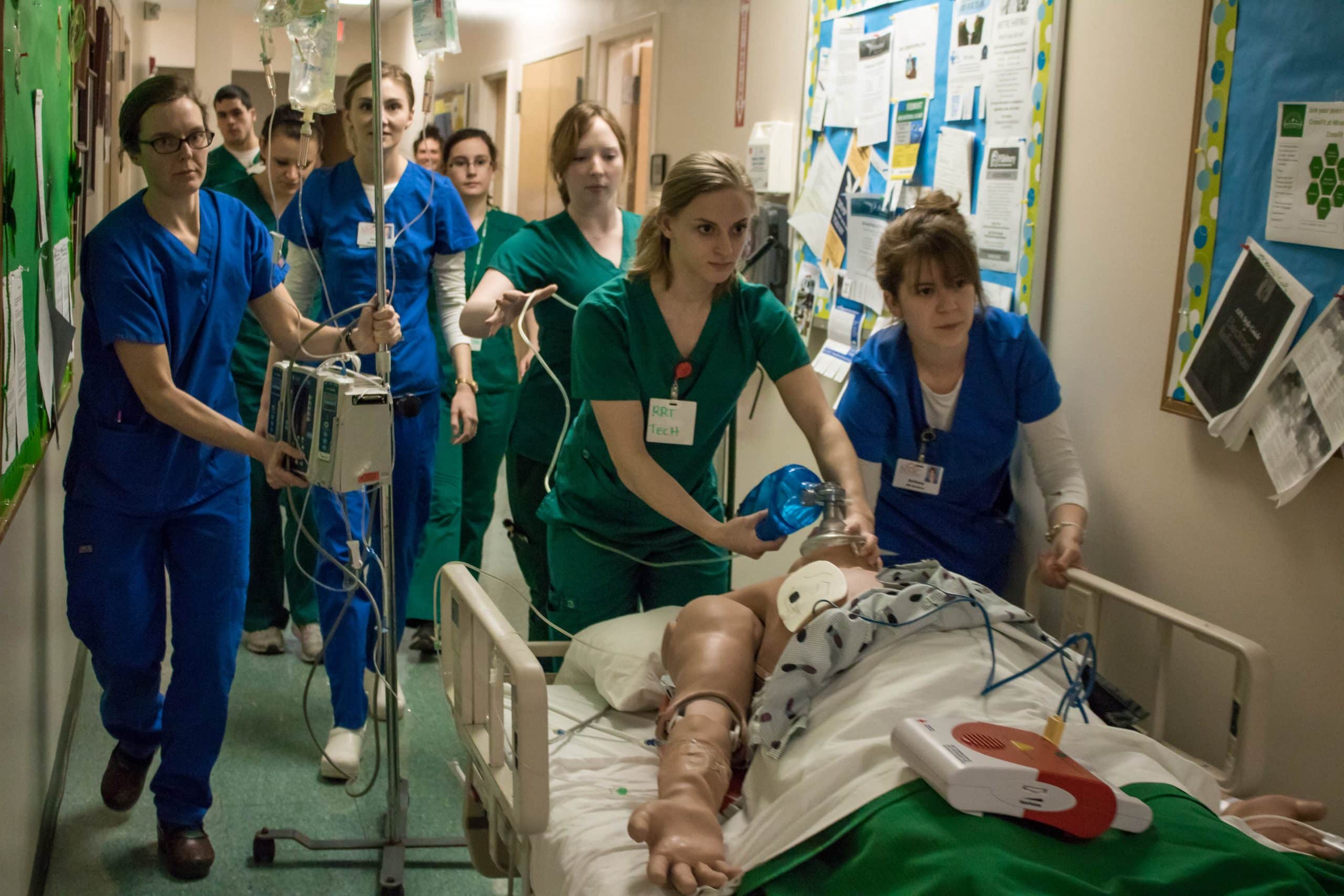 Group of nursing students work through a simulation during lab, hands on