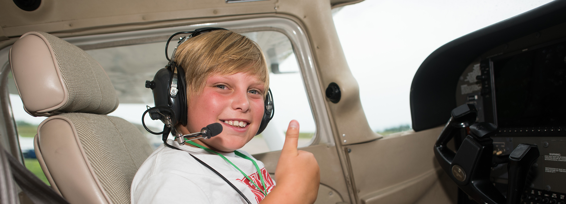 AeroCamp student looks excited to be in the cockpit! Professional Pilot technology, youth, camp, STEM