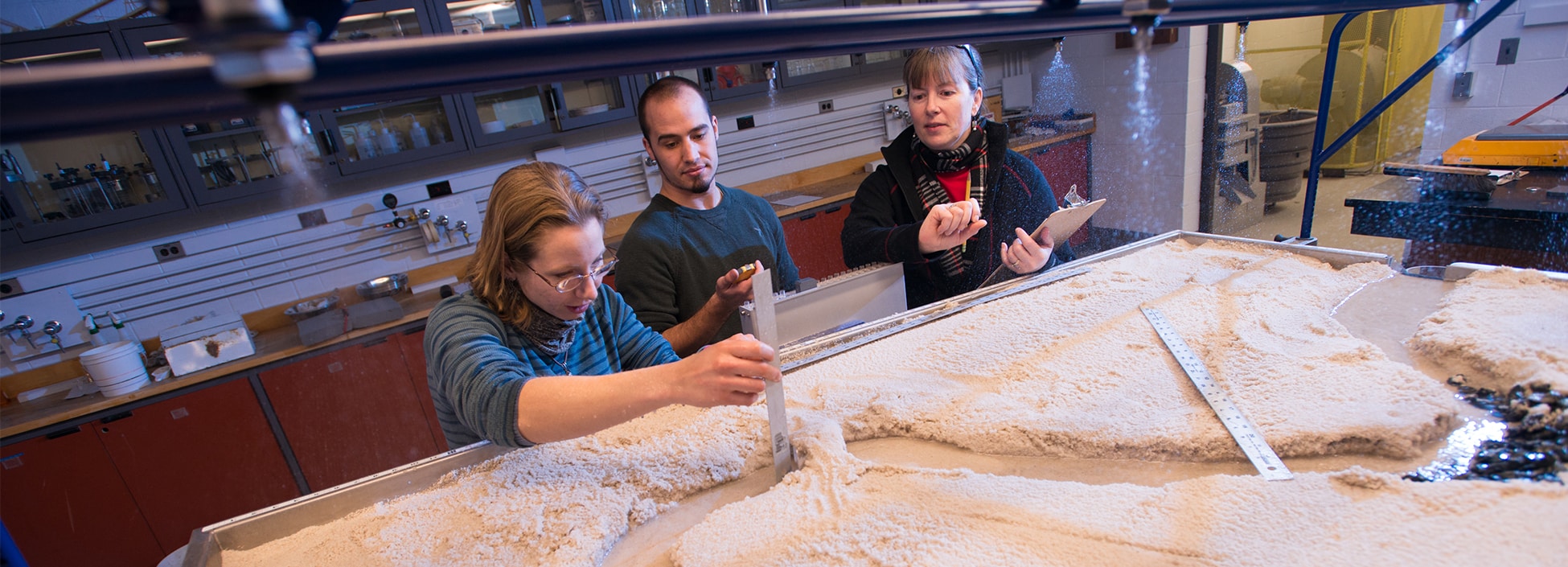 Civil students measure gullies and water flow with the sand table, hands on, engineering, STEM