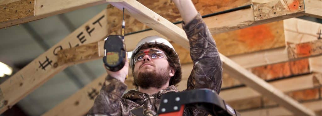 a construction student works to deconstruct a shed