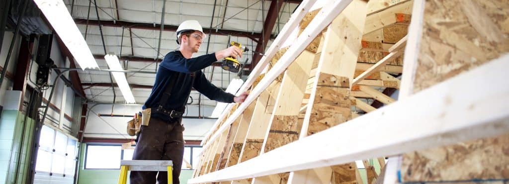 A construction student works on deconstructing a shed