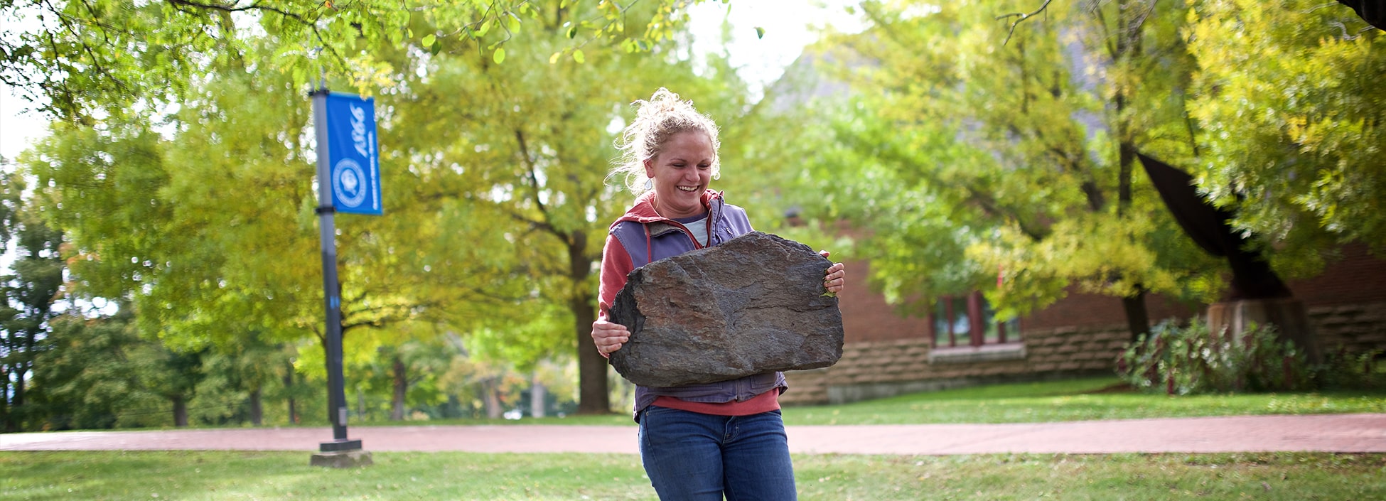 landscape contracting, female student, carrying rock, smiling