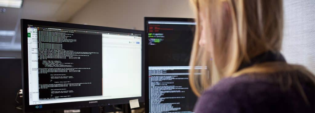 Vermont Tech graduate, Allison Miller, programming code at a computer monitor and keyboard, computer engineering