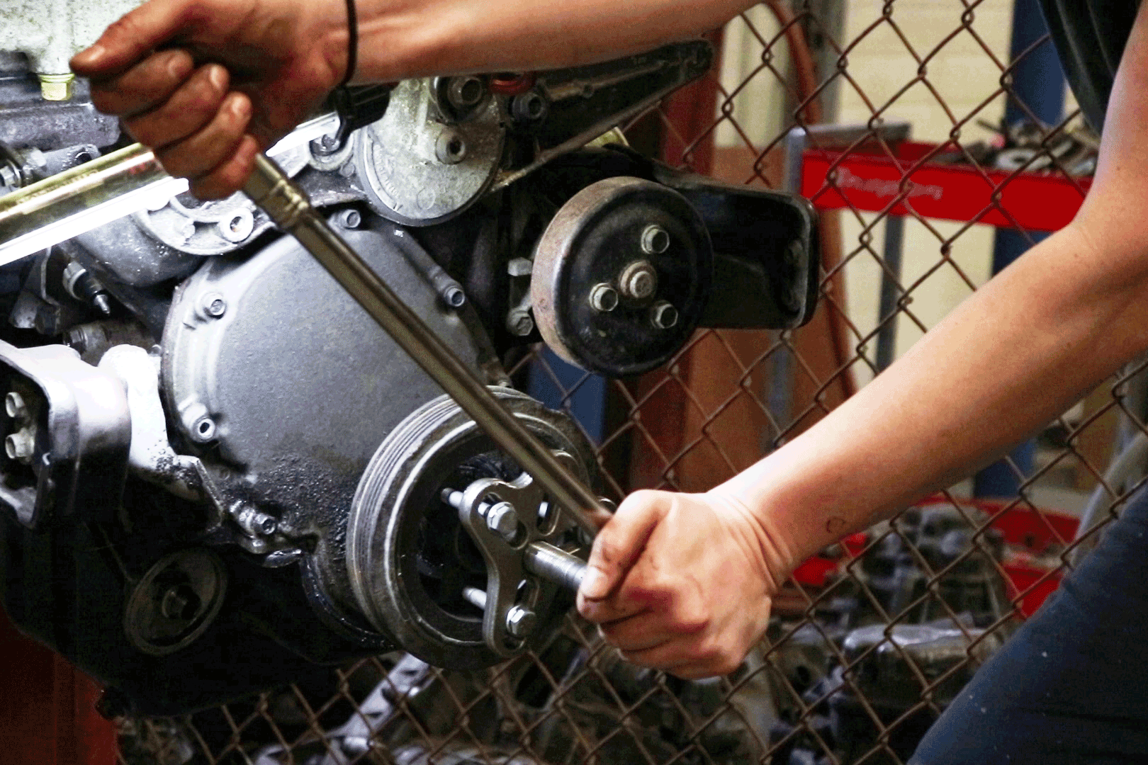 a female student works hard to disassemble this automotive engine, hands on, STEM