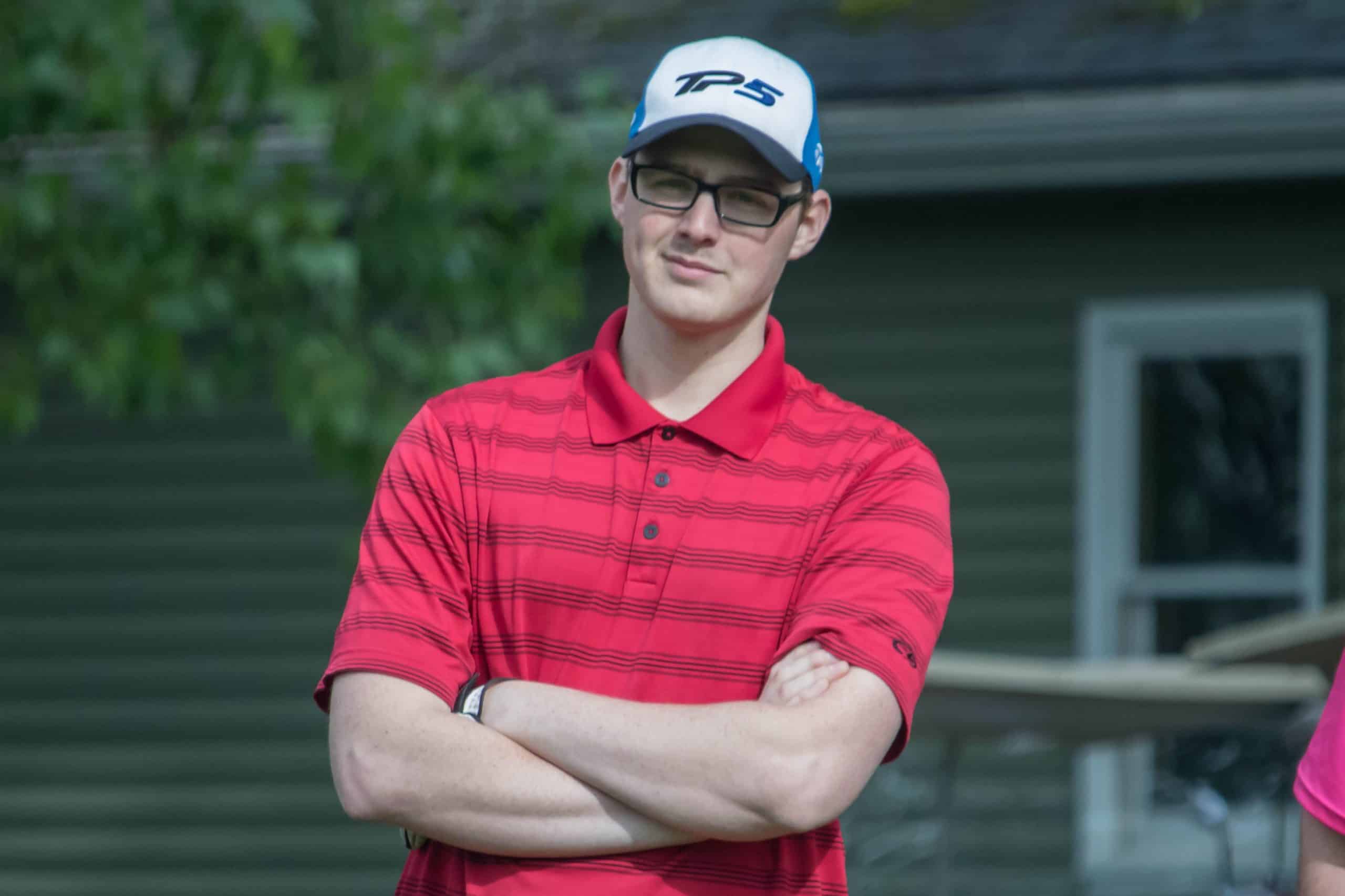 Male student, arms folded, smiling