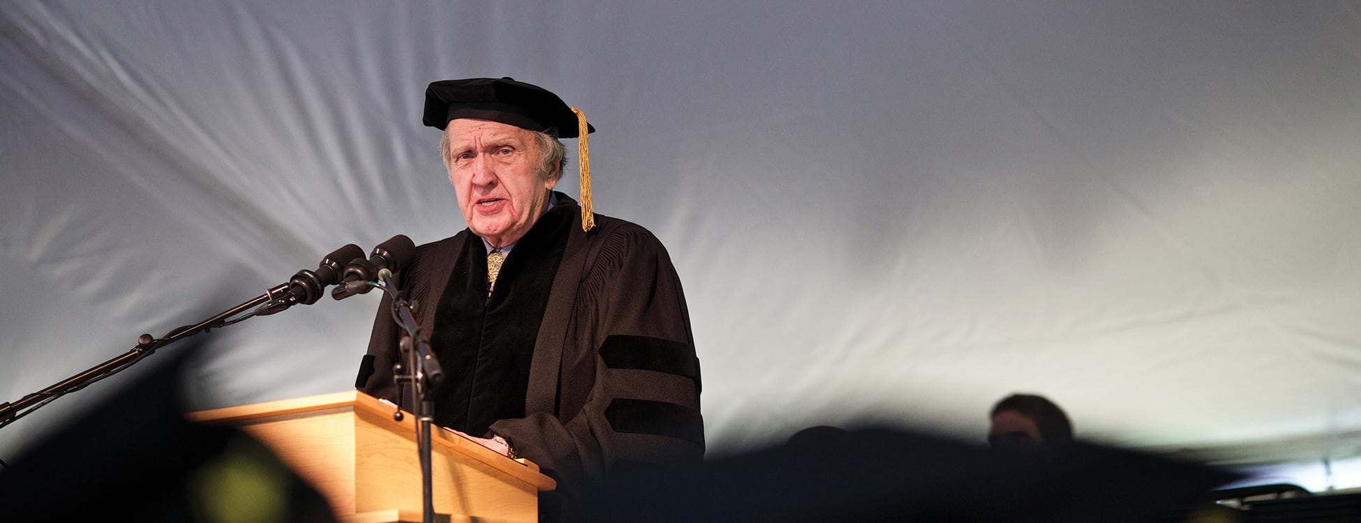 Squier speaking at podium at commencement ceremony