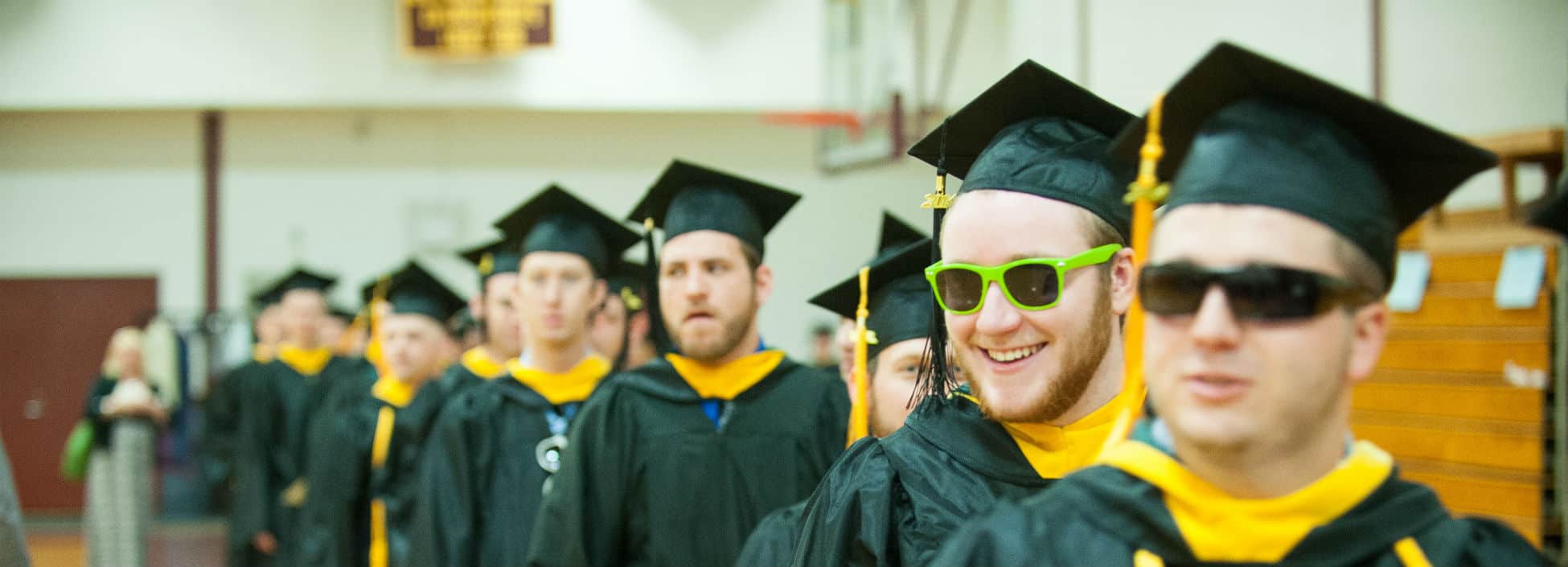 Graduates lining up for commencement, graduation, smiling, sunglasses, happy