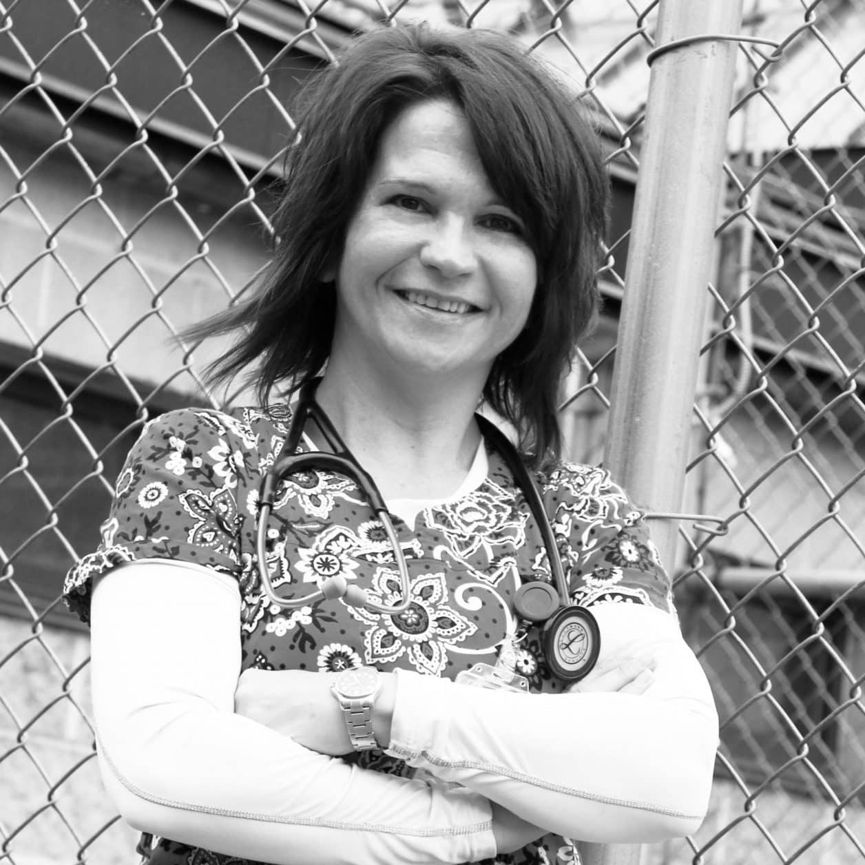 Female student, standing outside, arms crossed, nurse, stethoscope, smiling