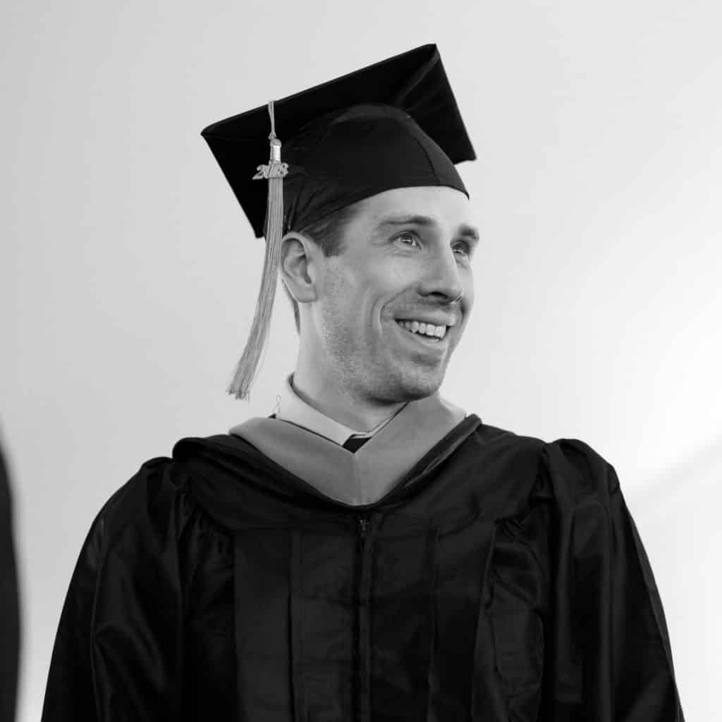 male student, commencement, graduation, smiling, under tent