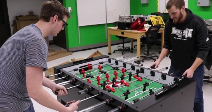 male students playing with foosball table, senior project, electromechanical engineering technology