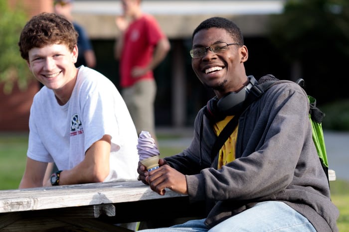 male students, sitting at picnic table, smiling, ice cream, diversity