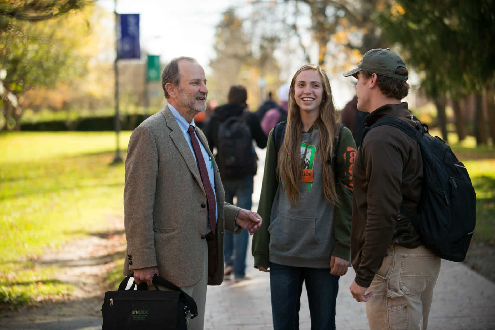 Professor talks with students, faculty, female student, male student, walkway, chatting, Randolph Center campus