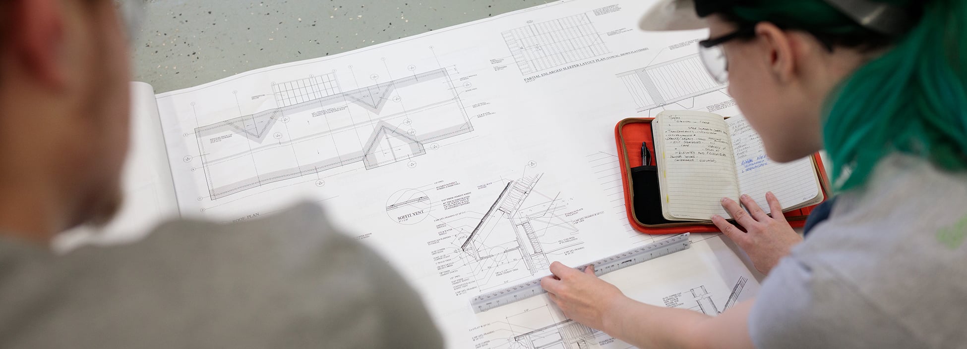 construction management students check the scale on the plans during class