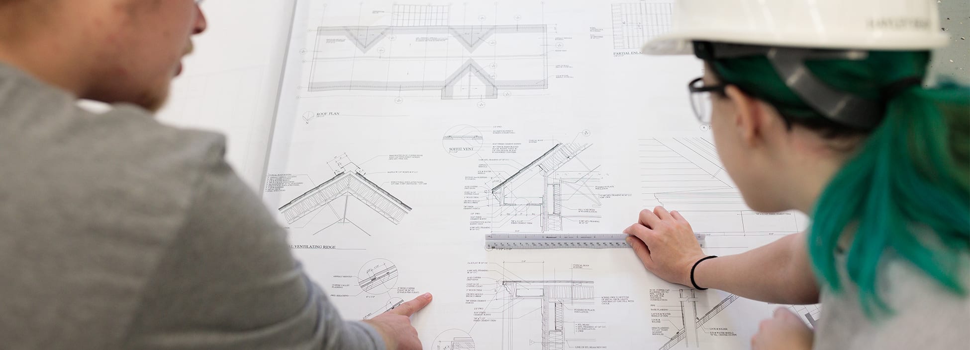 construction management students plan the work site using printed plans