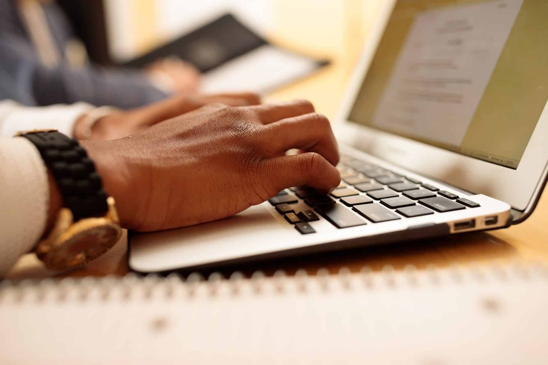 Male hands typing on laptop, diversity