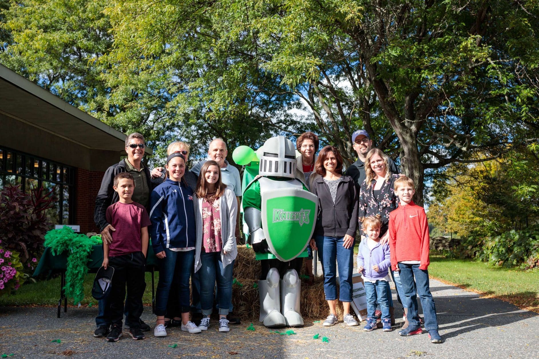 alumni homecoming, VTC Knight mascot, outside, smiling, group of visitors